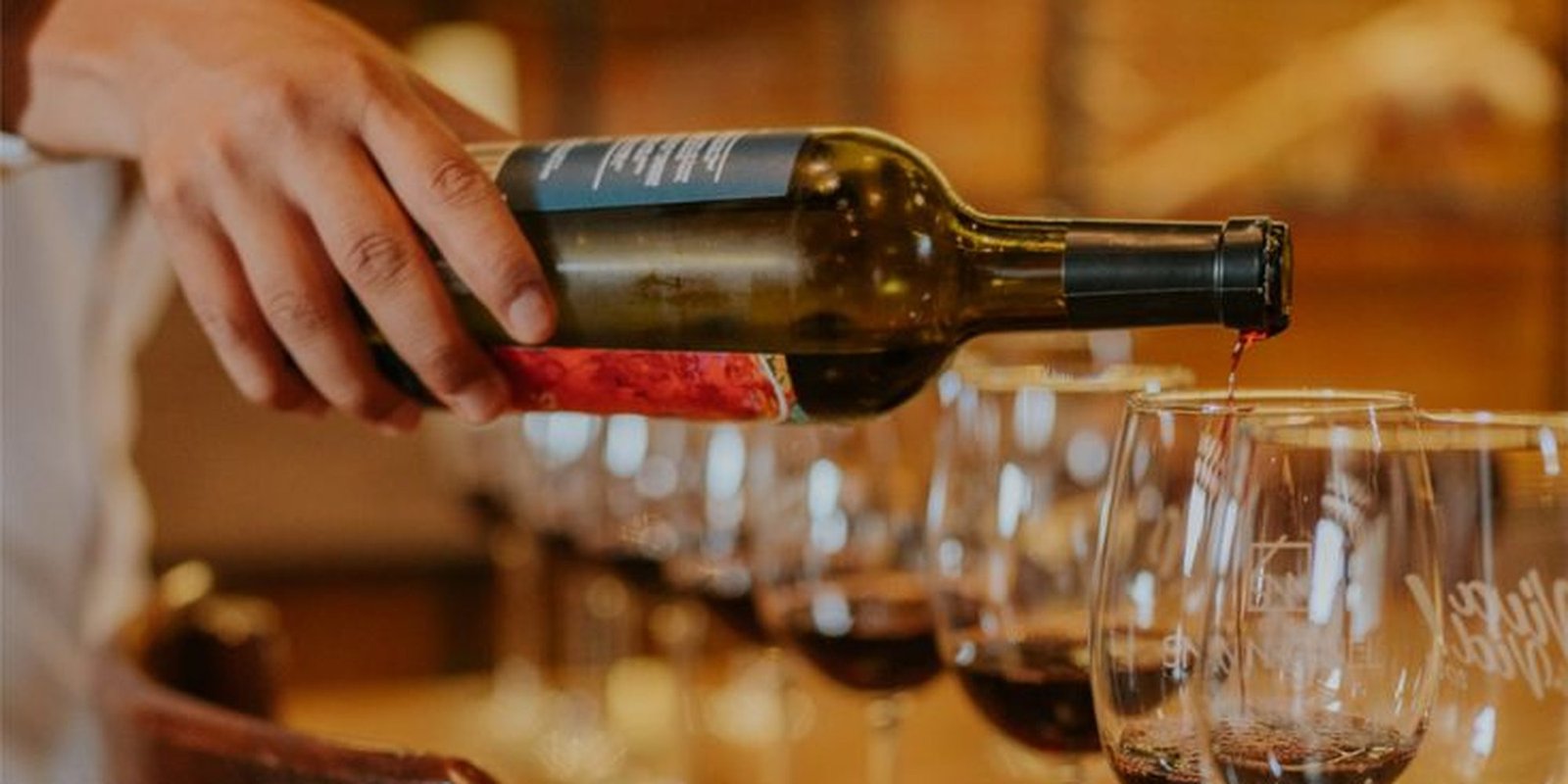 Vino tinto servido en una hilera de copas durante una cata