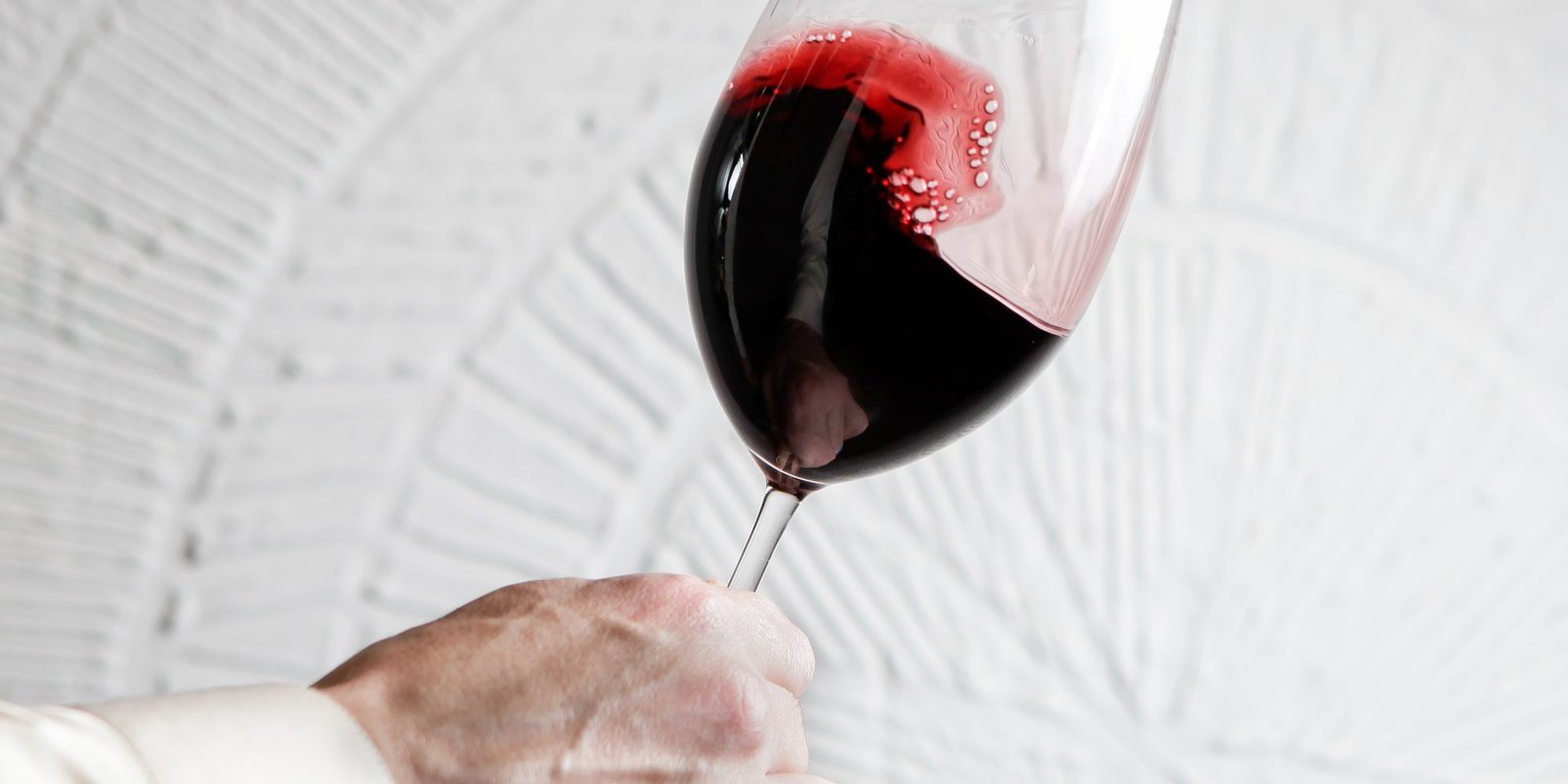 Copa de vino tinto girando con el reflejo de la luz
